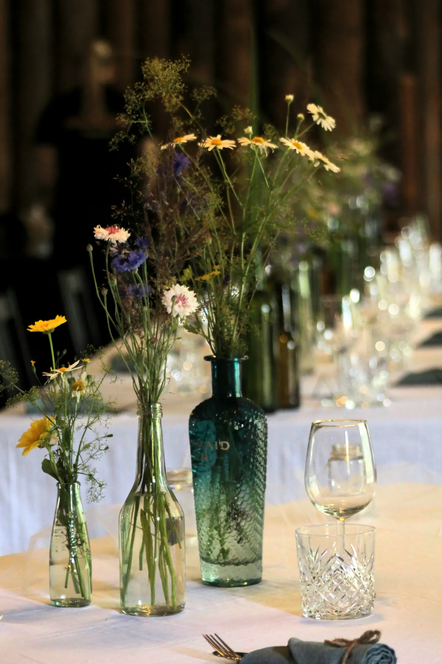 Fleurs sauvages disposées dans des bouteilles en verre