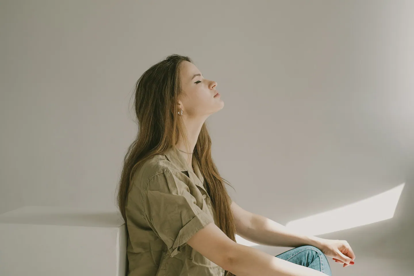 Personne assise respirant calmement dans une pièce claire