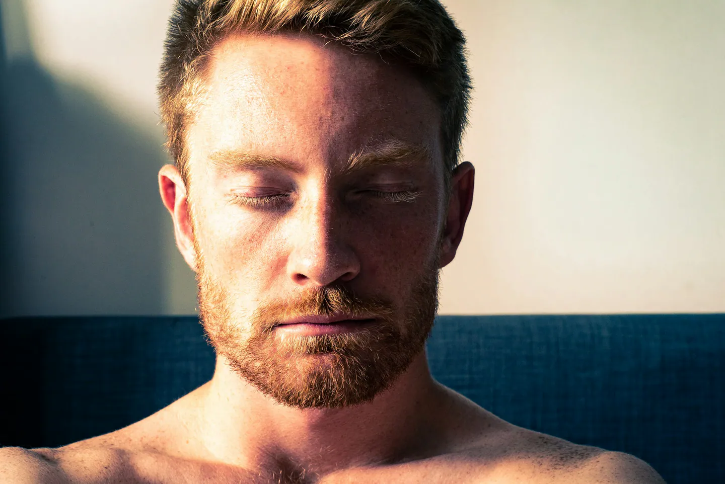 Portrait d’un homme les yeux fermés dans une lumière contrastée